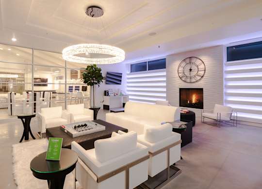 A modern living room with a fireplace and a large clock on the wall.