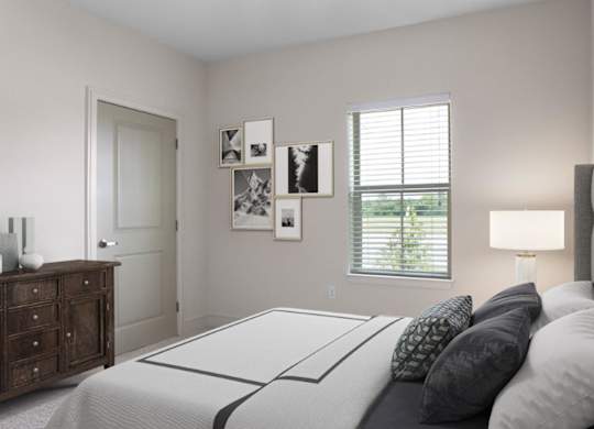 A bedroom with a bed, nightstand, and pictures on the wall.