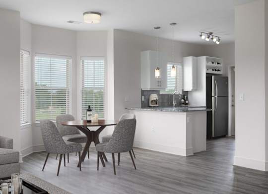 A modern kitchen with a dining table and chairs.