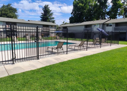 a swimming pool with a wrought iron fence around it