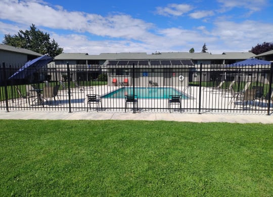 a swimming pool with a fence in front of a house