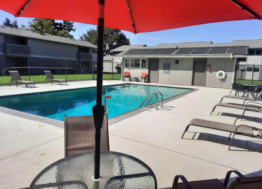our apartments have a large pool and a patio with an umbrella