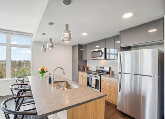 A modern kitchen with a large island and stainless steel appliances.