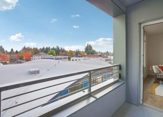 A balcony with a view of a town and trees.