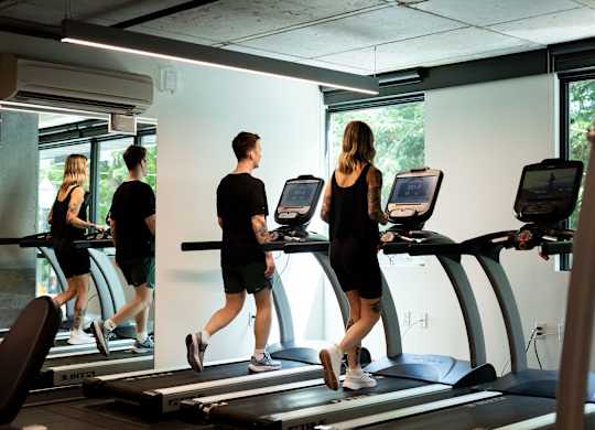 A group of people are exercising on treadmills in a gym.