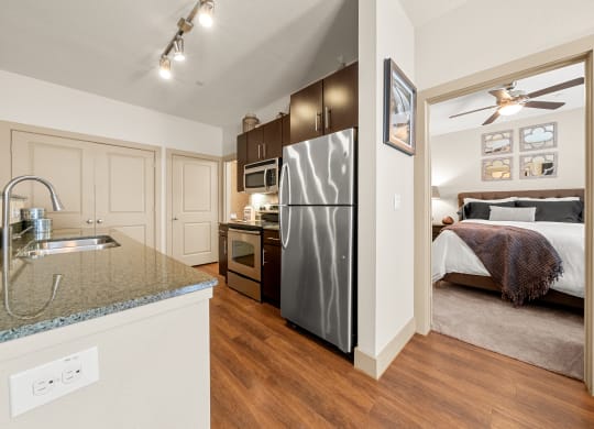Villas at Sundance Apartments  kitchen with a stainless steel refrigerator and a view of a bedroom