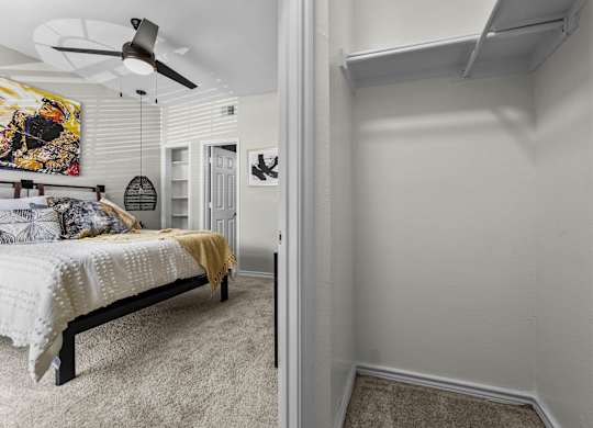 A bedroom with a bed and a ceiling fan.
