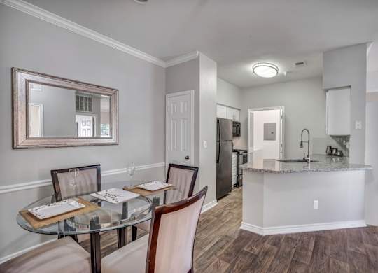 A dining room with a glass table and chairs.