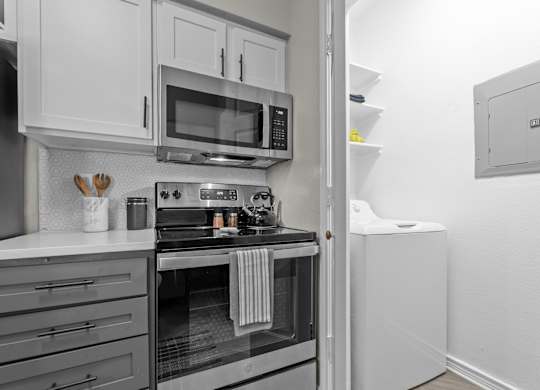 A modern kitchen with a stove, microwave, and oven.