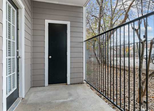 A black door is on the side of a house.