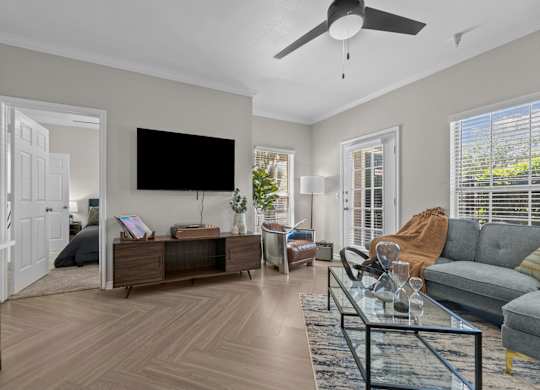 A living room with a flat screen TV mounted on the wall.