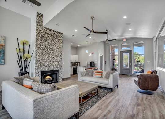 A modern living room with a fireplace and a grey sofa.
