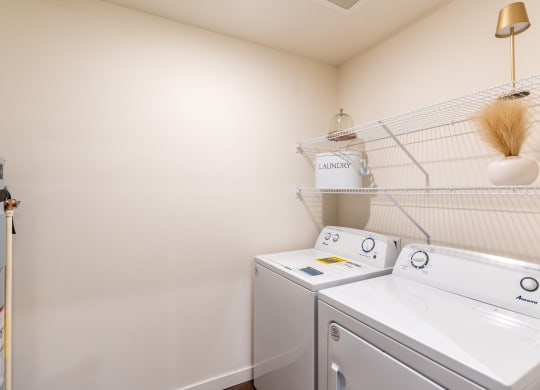 a washer and dryer in a laundry room with a shelf over the top