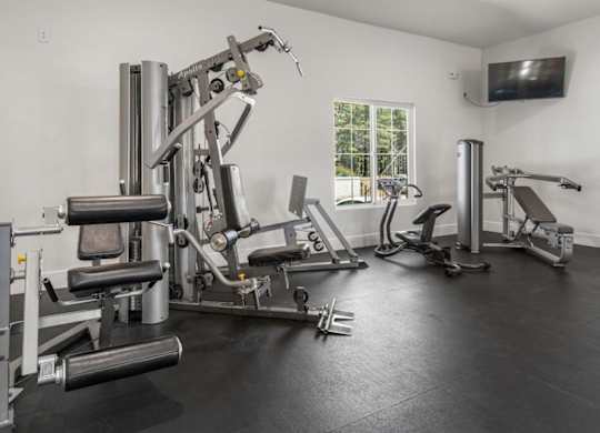 A well equipped home gym with a television.