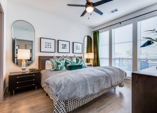 a bedroom with a large bed and a ceiling fan
