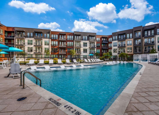 a swimming pool with an apartment building in the background