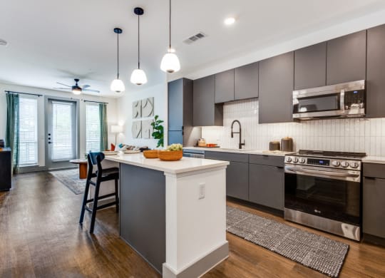 an open kitchen with a large island and stainless steel appliances