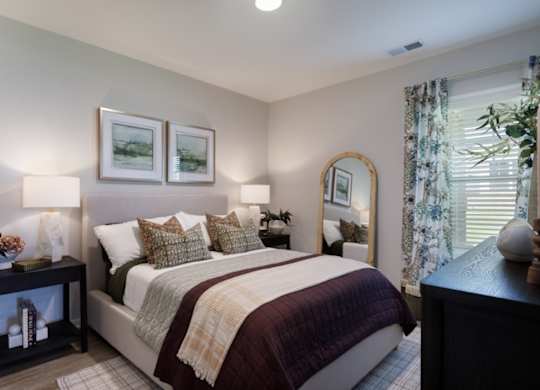 A bedroom with a large bed and a mirror on the wall.