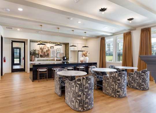 A modern kitchen with a breakfast bar and patterned chairs.