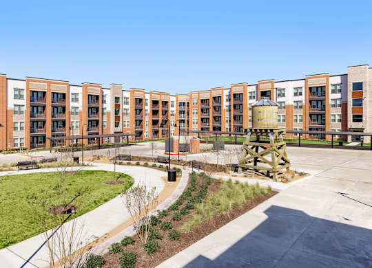 A large building complex with a fountain in the middle of a courtyard.