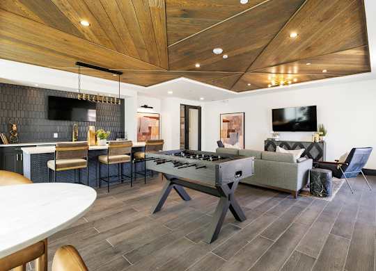 A modern living room with a wooden ceiling and a white dining table.