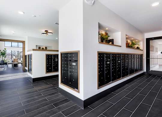 A modern kitchen with black tiles and wooden cabinets.
