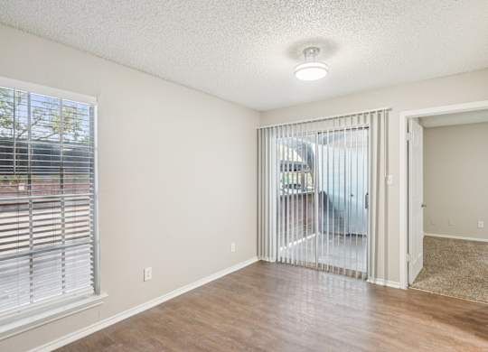 A room with a sliding glass door leading to a balcony.