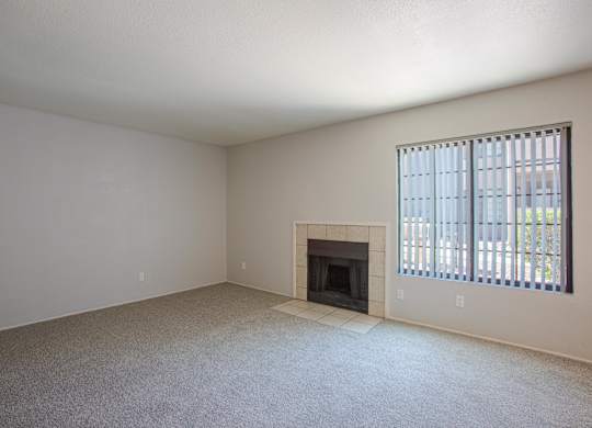 A room with a fireplace and a window with blinds.
