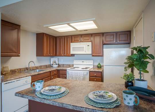 A kitchen with brown cabinets and white appliances.