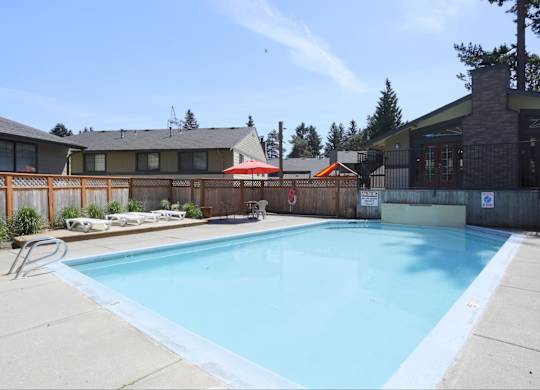 Large blue community swimming pool at The Rosewood Apartments in Vancouver, Washington.