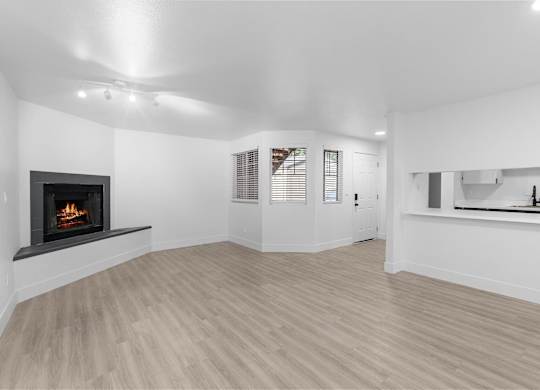 Spacious living room with a fireplace and wooden-style  flooring at The Rosewood Apartments in Vancouver, Washington.