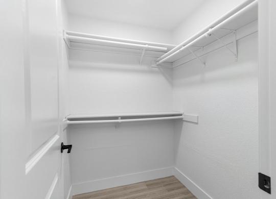 A white room with a shelf and a black electrical outlet.