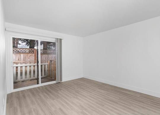 A room with a sliding glass door leading to a backyard.