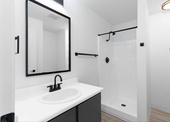 A modern bathroom with white walls and countertops with matte black finishes at The Rosewood Apartments in Vancouver, Washington.