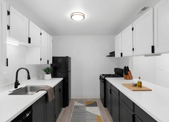A kitchen with black cabinets and white countertops at The Rosewood Apartments in Vancouver, Washington.