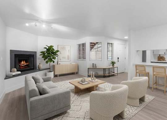 A modern living room with white walls and a fireplace at The Rosewood Apartments in Vancouver, Washington.