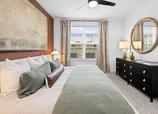 A bedroom with a large bed and a painting on the wall.