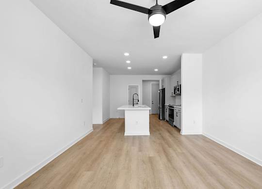 A room with a ceiling fan and wooden flooring.