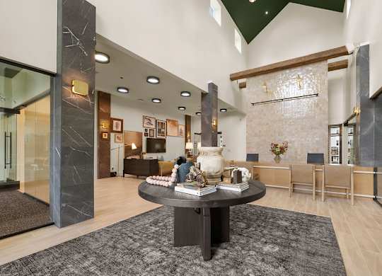 A modern living room with a black coffee table in the center.