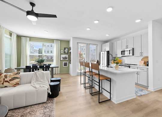 A modern kitchen with a white island and bar stools.