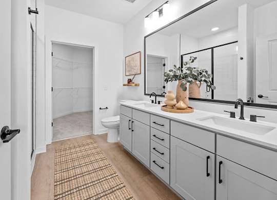 A bathroom with a white door and a brown rug.