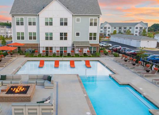 A large white building with a pool in front of it.