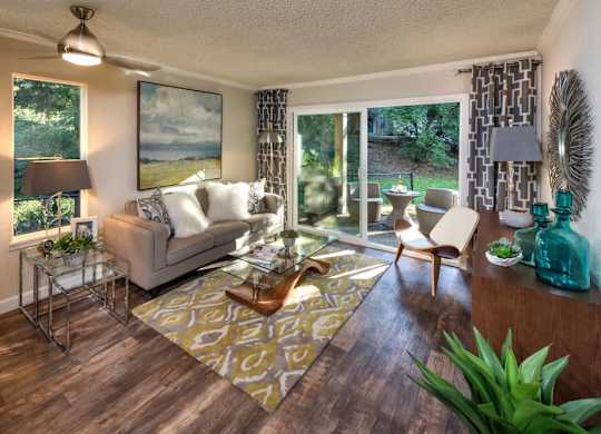 A living room with a couch, chairs, and a rug.