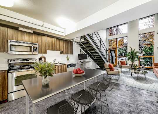 A modern kitchen with a stainless steel table and chairs.