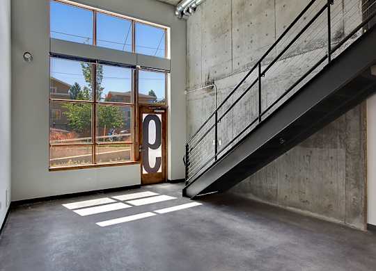 A room with a concrete wall and a staircase.