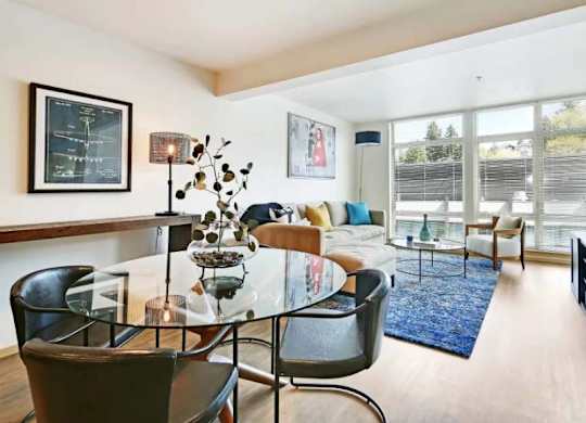 A modern living room with a glass table and chairs.