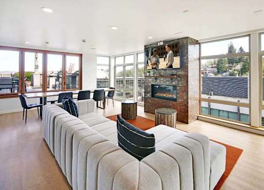 A living room with a long couch and a fireplace.