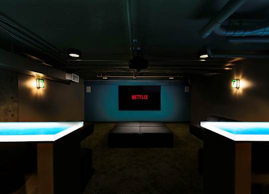 A room with a screen displaying the Netflix logo.