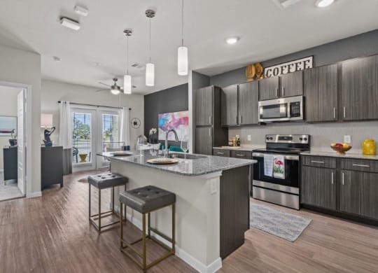 a kitchen with a large island with two stools