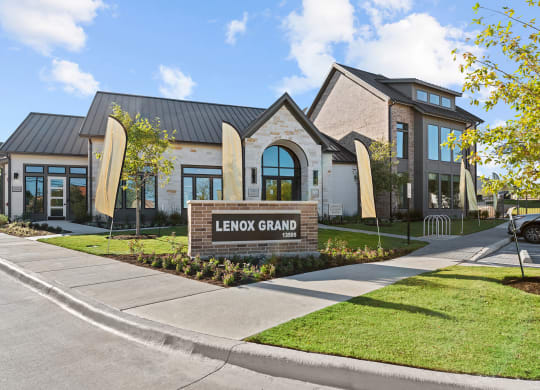 the grand building is shown with a sidewalk and grass at Lenox Grand, Austin Texas